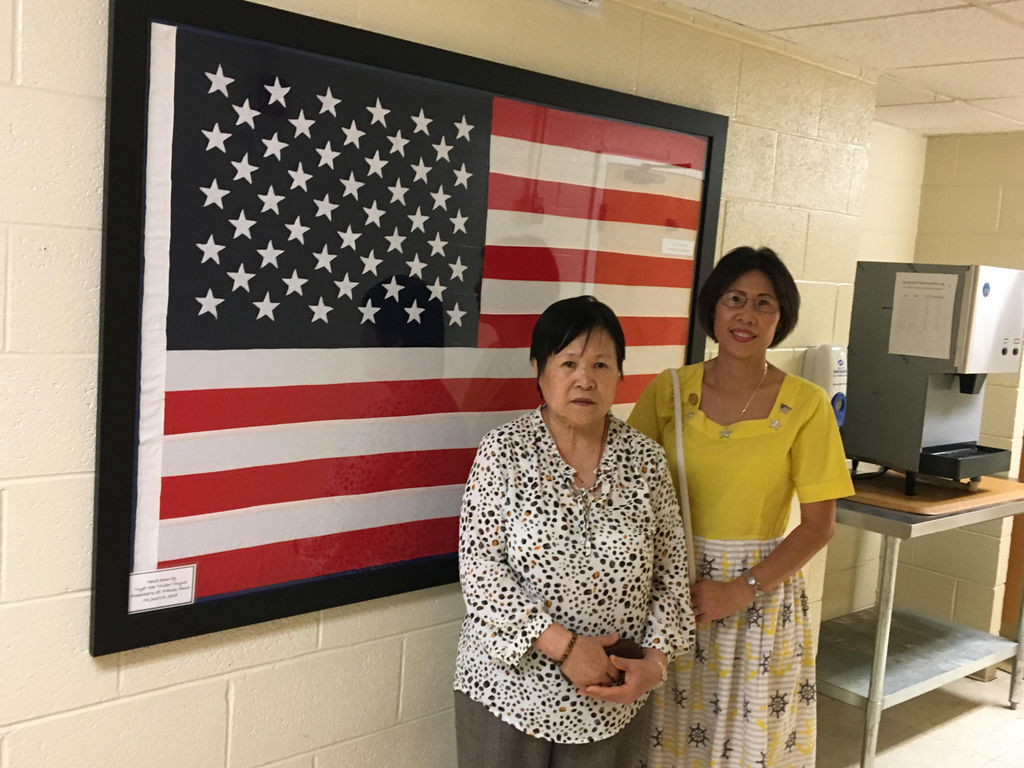 Pictured above is Vivian (on the right) and her sister, Ann standing in front of the American Flag Vivian hand sewn and presented it to the St. Francis House on June 14, 2018.