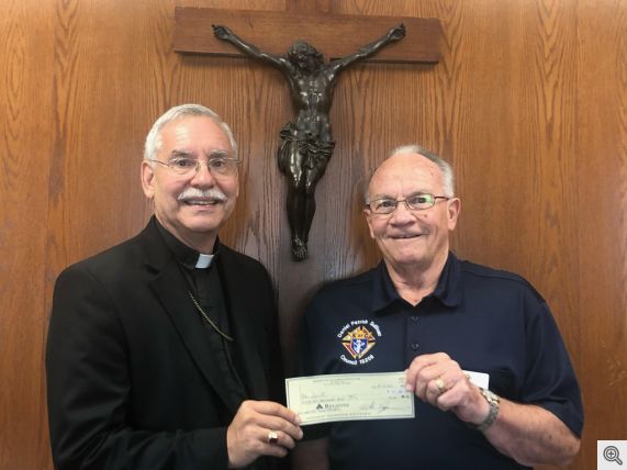 Grand Knight Rick Phillips presenting a check for 51,000.00 to Bishop Taylor