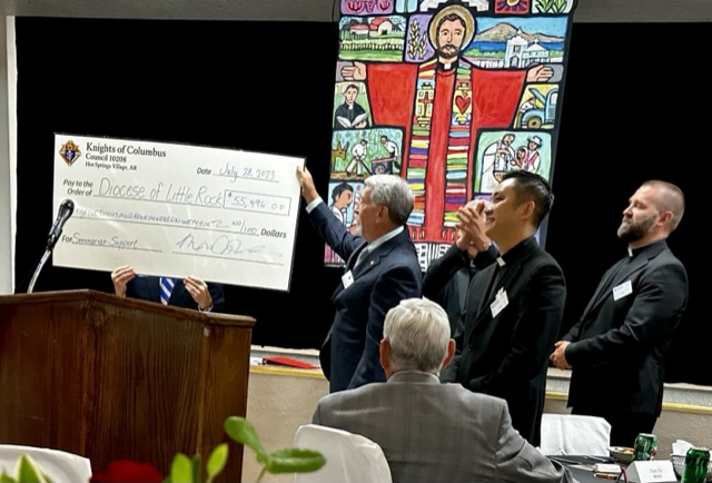 Grand Knight Gary Wolfer presents a check for $55,496.00 to Bishop Taylor